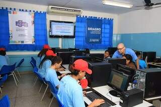 Alunos mexendo no computador em laboratório de informática de escola municipal (Foto: Divulgação/Prefeitura de Campo Grande)