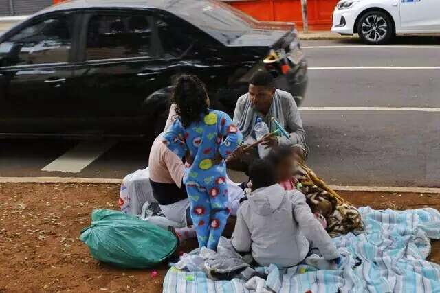 Crian&ccedil;as enfrentam frio em canteiro de avenida para fam&iacute;lias lucrarem no sinal