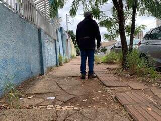 Gildo mostra a dificuldade de caminhar em calçada quebrada misturada com pisto tátil (Foto: Bruna Marques)