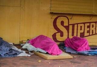 Moradores de rua dormindo debaixo de cobertura de trailer na Avenida Bandeirantes (Foto: Marcos Maluf)