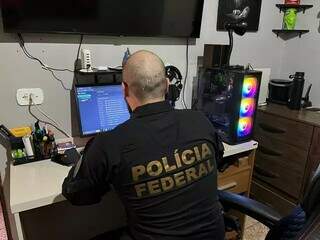 Policial federal checando computador de investigado em uma das operação de combate ao abuso sexual infantil. (Foto: Arquivo/Campo Grande News)