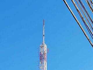 Homem quase no topo da torre de emissora de televisão. (Foto: Kamila Alcântara)