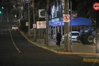 Mulher anda bem agasalhada pela Avenida Afonso Pena (Foto: Henrique Kawaminami)