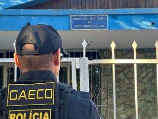 Policial do Gaeco em frente ao prédio da Federação de Futebol de Mato Grosso do Sul. (Foto: Marcos Maluf)