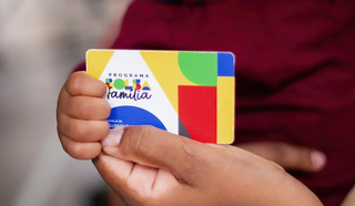 Beneficiário segura cartão do Bolsa Família (Foto: Lyon Santos/MDS)