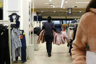 Vendedora organiza roupas em loja de departamento (Foto: Paulo Francis)