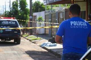 Perícia no local e vítima caída em calçada. (Foto: Henrique Kawaminami)