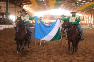 Cavaleiros segurando a bandeira de Mato Grosso do Sul no Parque do Peão (Foto: Divulgação)