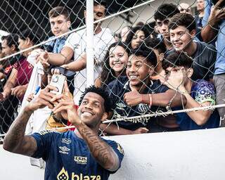 Zagueiro Gil tira foto com torcedores do Santos após treino (Foto: Raul Baretta/SFC)