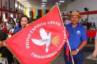 Noraldino e a esposa, Gissiley, seguram a bandeira do Divino Espírito Santo (Foto: Henrique Kawaminami)