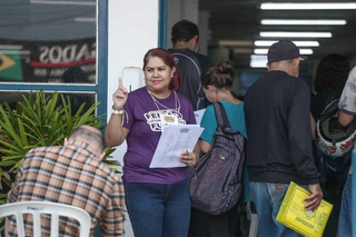 Agente auxilia na distribuição de senhas de feirão de empregos, em Campo Grande. (Foto: Arquivo/Paulo Francis)