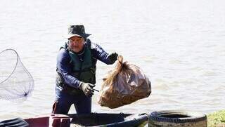 Paulo Benitt retirando lixo de seu caiaque no Lago do Amor (Foto: Alex Machado)