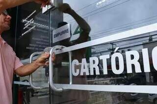 Funcionário abrindo porta de Cartório, em Campo Grande (Foto: Arquivo/Campo Grande News)