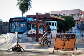 Ciclista e onibus do transporte coletivo em local onde estava sendo constuido uma parada do coletivo (Foto: Henrique Kawaminami)