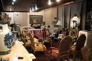 Sala de estar da casa é repleta de móveis feitos de madeira ou em mármore (Foto: Osmar Veiga)