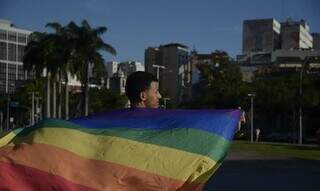 Jovem segura bandeira que representa a comunidade LGBTQIA+ (Foto: Fernando Frazão/Agência Brasil)