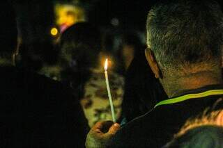 Fiel carrega vela durante procissão na Avenida Afonso Pena. (Foto: Juliano Almeida)