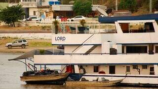 Barco hotel de luxo com barcos de pesca acoplados na embarcação (Foto: Alex Machado)