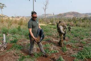 Agentes plantando sementes nativas em área desmatada para cultivo da maconha (Foto: Divulgação)