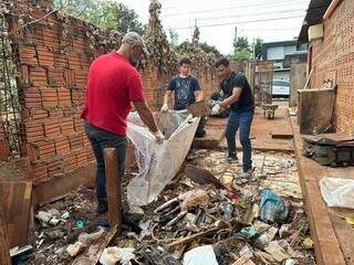 Voluntários recolhendo lixo na manhã deste domingo (30), no Bairro Rita Vieira. (Foto: Marcos Maluf)
