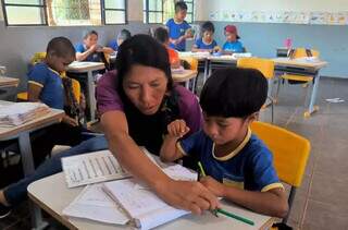 Professora indígena alfabetizando criança na língua portuguesa na Escola Municipal Indígena Araporã, na Reserva Indígena de Dourados (Foto: Paula Maciulevicius)
