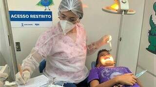 Dentista atende criança em odontomóvel da Prefeitura de Campo Grande (Foto: Divulgação/Prefeitura de Campo Grande)