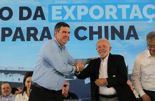 Governador Eduardo Riedel (PSDB) segurando a mão do presidente Luiz Inácio Lula da Silva (PT) em abril deste ano, durante evento que marcou a exportação da carne da JBS para China (Foto: Arquivo/Saul Scharmm)