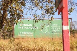 Placa do Parque Cachoeiras do Ceuzinho, em meio ao mato alto (Foto: Henrique Kawaminami)