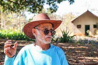 Onofre Pauferro, 75 anos, com a estrutura da escola abandonada ao fundo (Foto: Henrique Kawaminami)