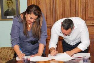 João Santos assina termo de compromisso, ao lado da secretaria de cultura de Campo Grande, Mara Gurgel (Foto: Juliano Almeida)