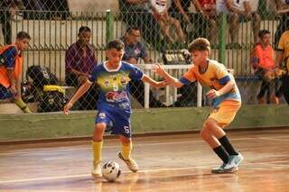 Jogadores disputam a posse da bola durante torneio estadual de futsal. (Foto: Reprodução/Escola Pelezinho)