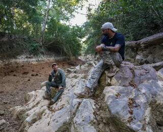 Nisroque (à esquerda) e Sérgio sentados em pedras onde passavam de caiaque. (Foto: Paulo Francis)