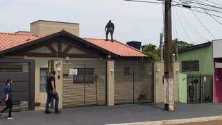 Policial sobre telhado de casa no Jardim Água Boa, em Dourados (Foto: Arquivo/Campo Grande News)