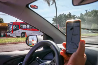 Motorista de aplicativo circula ao lado de ônibus na Capital. (Foto: Arquivo/Campo Grande News)