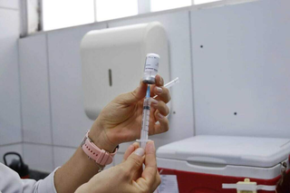 Servidora segura dose de vacina em unidade de saúde da Capital. (Foto: Paulo Francis, Arquivo/Campo Grande News)