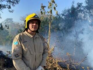 Cabo Elieber Machado do Corpo de Bombeiros em frente a vegetação que pegou fogo (Foto: Clara Farias)