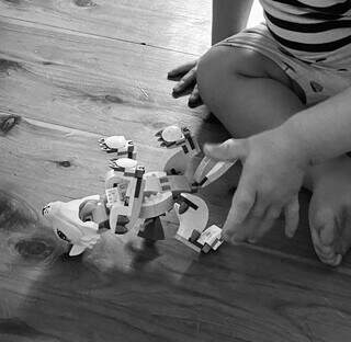 Criança brinca com dinossauro de pecinhas (Foto: Freepik)