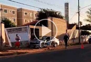 Carro atinge portão de casa após colisão com caminhonete 