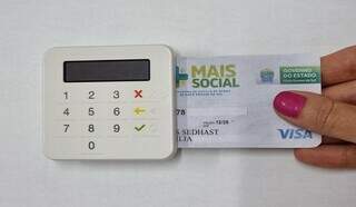 Cartão do Programa Mais Social sendo inserido em maquininha (Foto: Divulgação/Portal MS)