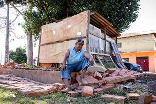 Eudes Pereira de Magalhães sentando no que restou da construção. (Foto: Henrique Kawaminami)