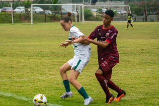Menina protegendo bola na lateral de campo em jogo com equipes mistas (Foto: Divulgação/FES)