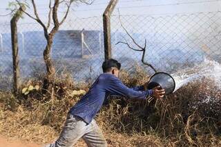 Moradores tentam apagar fogo com baldes na aldeia Água Bonita (Foto: Paulo Francis)