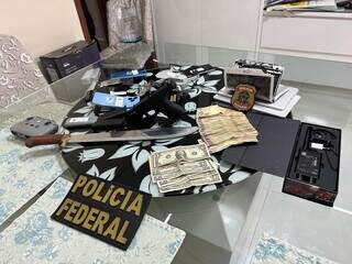Dinheiro, pistola, facão e dispositivos eletrônicos apreendidos na casa de traficante (Foto: Divulgação)