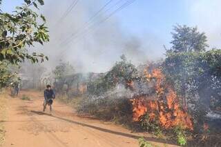 Morador da aldeia tentando apagar fogo com balde de água (Foto: Paulo Francis)