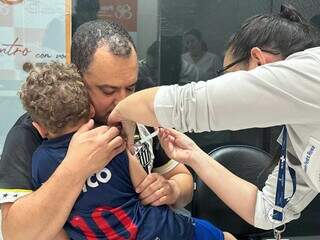 Menino é acolhido pelo pai durante vacinação em shopping da Capital (Foto: Marcos Maluf/Arquivo)