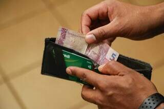 Homem guardando dinheiro em sua carteira (Foto: Arquivo)