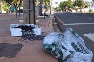 Sacola de carvão e isopor foram deixados na calçada da Praça do Rádio Clube. (Foto: Osmar Veiga)