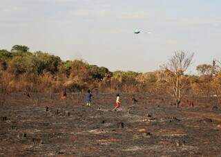 Crianças brincam em terreno que teve vegetação totalmente queimada após incêndio (Foto: Osmar Veiga)