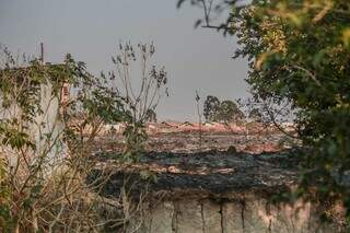 Como está na manhã de hoje a área queimada; há várias residências ao fundo (Foto: Marcos Maluf)