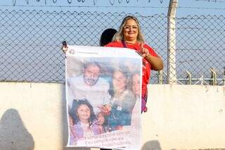 Professora com cartaz aguardando no aeroporto (Foto: Henrique Kawaminami)